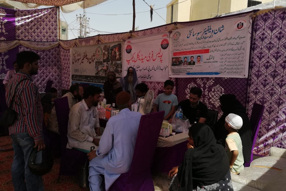 A free medical camp under a marquee, with residents waiting to be seen.