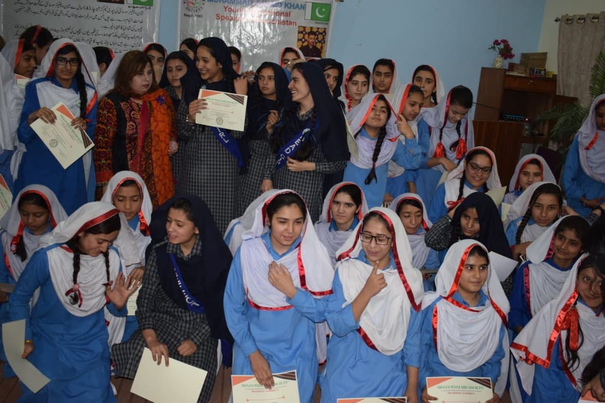 Students holding Shaan Welfare certificates after a ceremony.