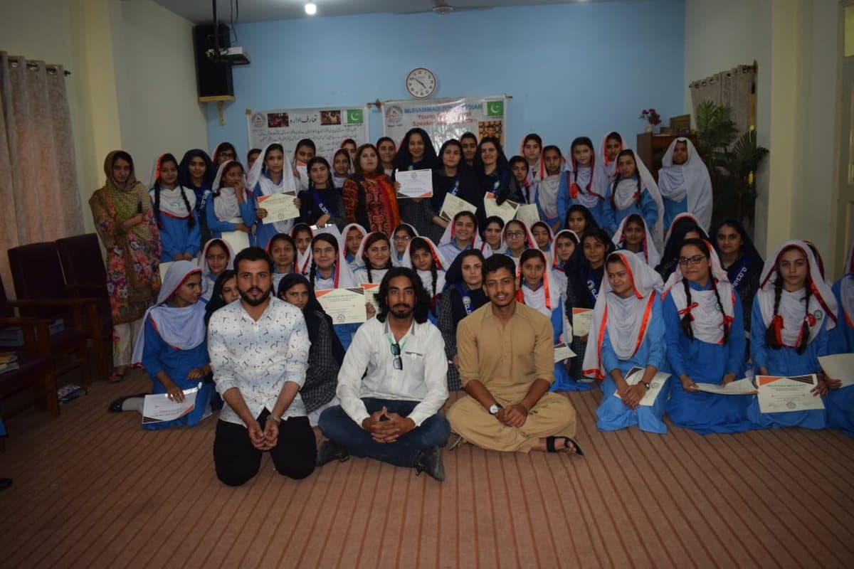 Around fifty schoolgirls in uniform with Shaan Welfare certificates, seated with staff.
